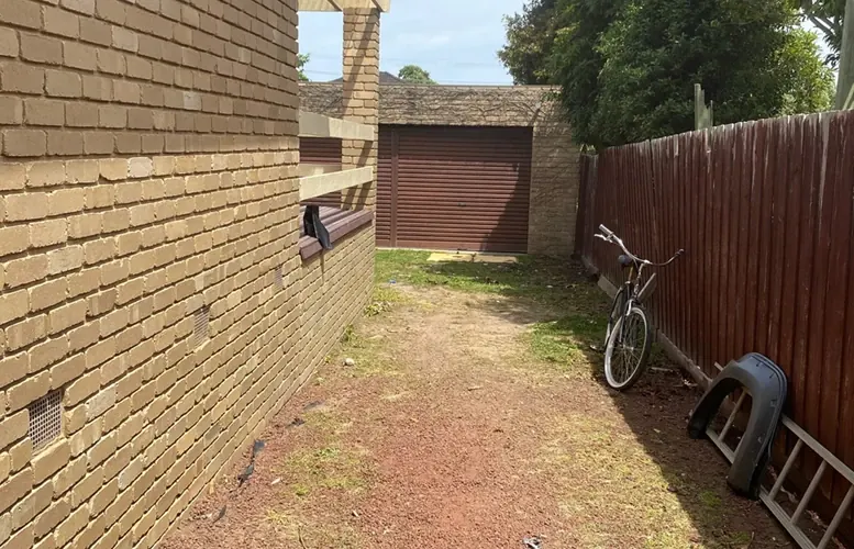 After: the same side passage cleared, with only a bike left against the fence